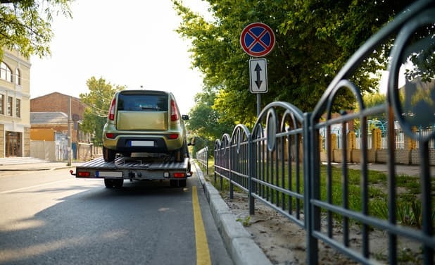 Um camião de reboque leva um carro mal estacionado