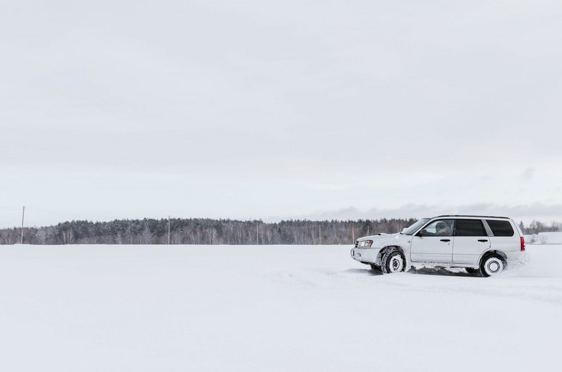 Carro 4x4 branco a conduzir na neve